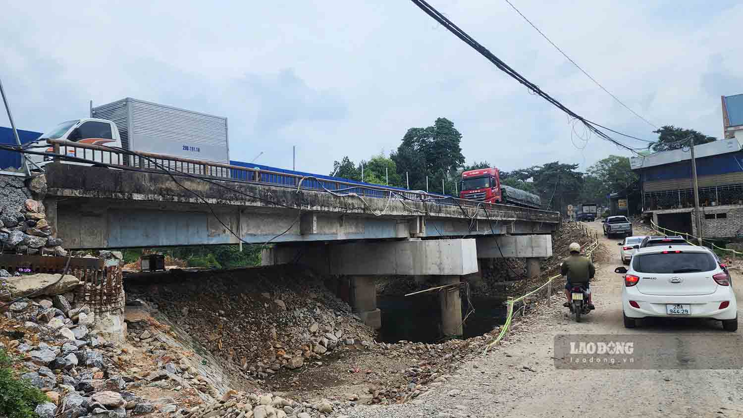 Chiều ngược lại, phương tiện di chuyển qua ường tránh tạm phía hạ lưu cầu, rộng 5m, mặt đường rộng 4m. Ảnh: Nguyễn Tùng.