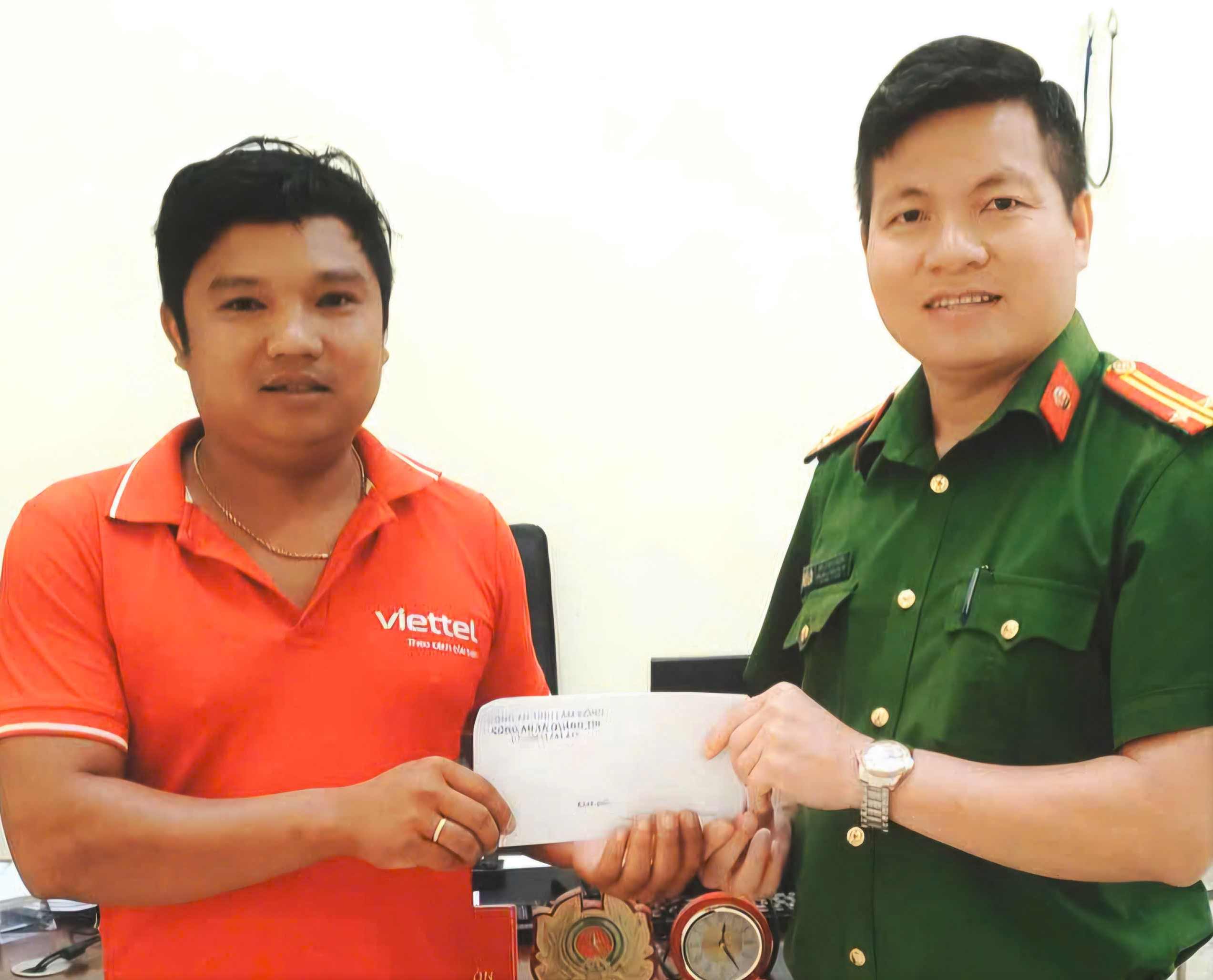 Anh Lê Văn Cương giao nộp số tiền 7 triệu đồng chuyển khoản nhầm cho Công an xã Quảng Tín. Ảnh: Công an xã Quảng Tín