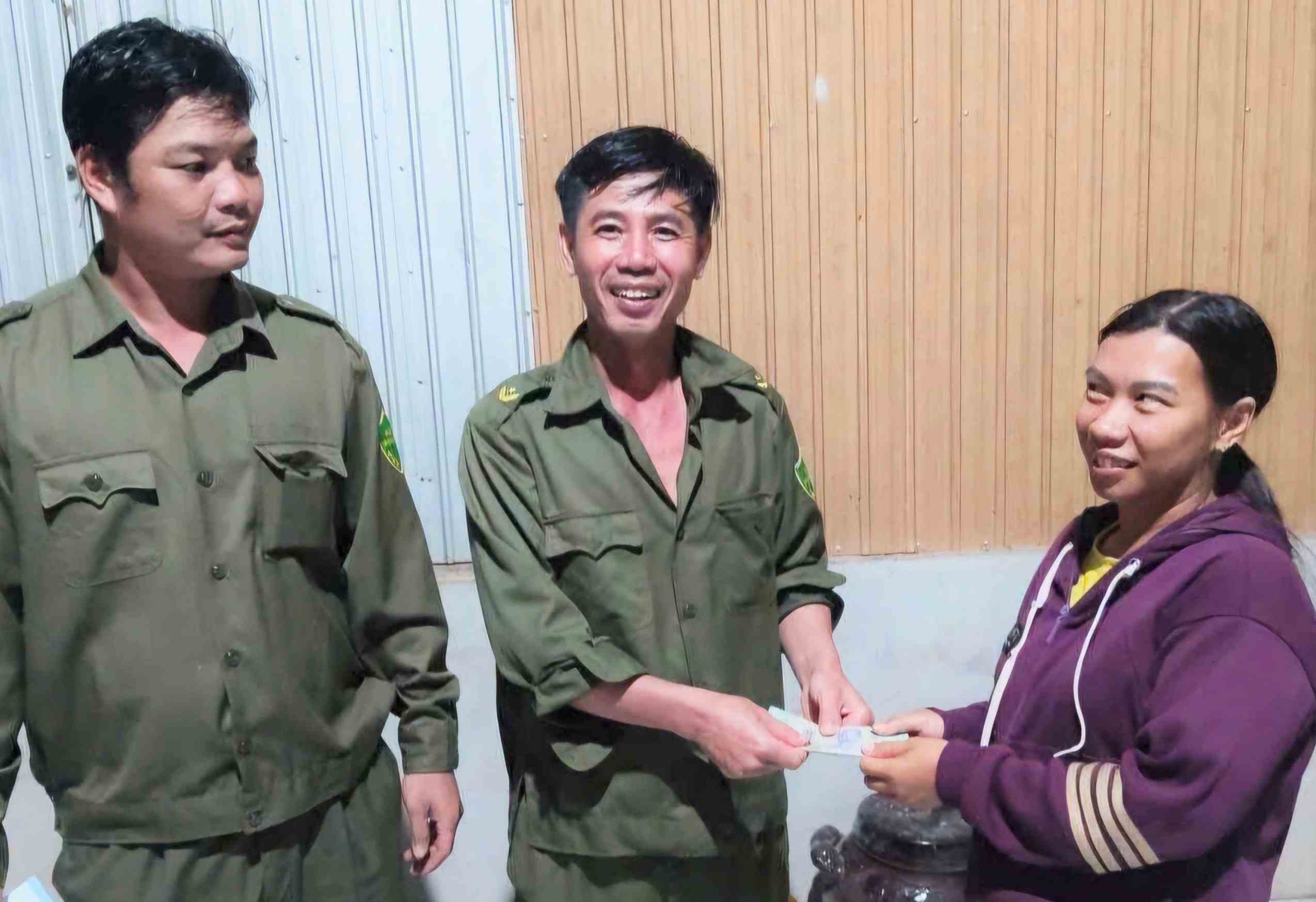 Functional forces receive 10 million VND handed over by Ms. Pham Thi Lan. Photo: Quang Tin Commune Police