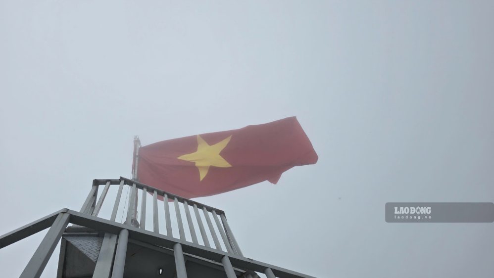Lá cờ đỏ sao vàng tung bay trên đỉnh núi Ảnh: Tân Văn