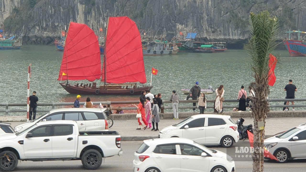 Du khách dừng xe để chụp ảnh cùng thuyền buồm ba vách trên đường Trần Quốc Nghiễn, đoạn qua phường Hồng Gai. Ảnh: Nguyễn Hùng