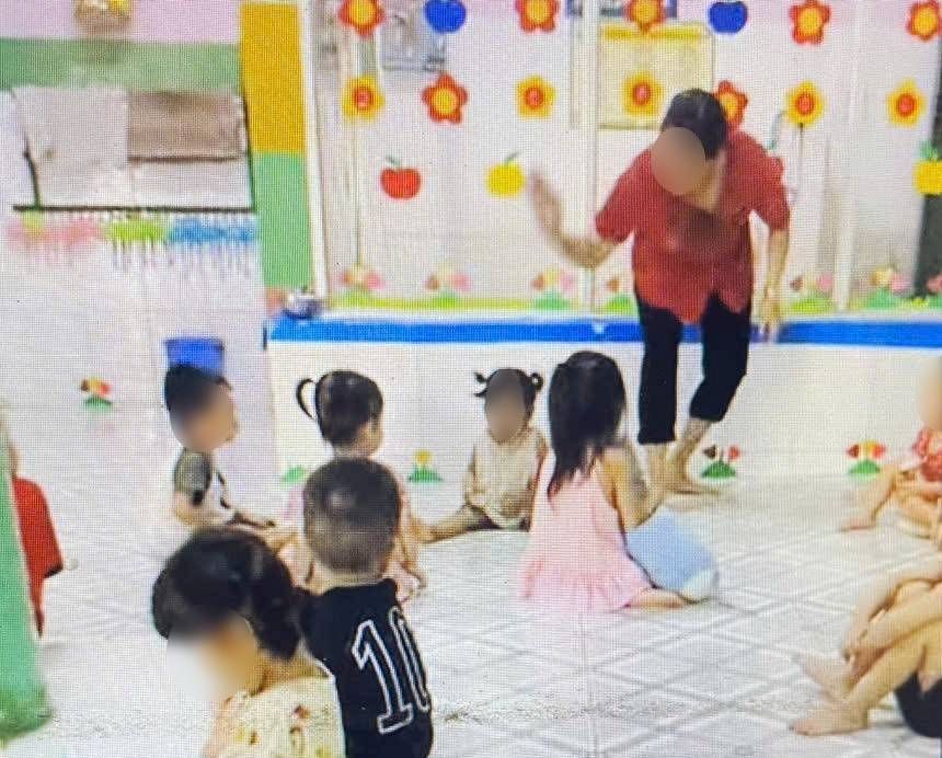 Bảo mẫu dùng tay vỗ lên đầu cháu bé. Ảnh: Bạn đọc cung cấp
