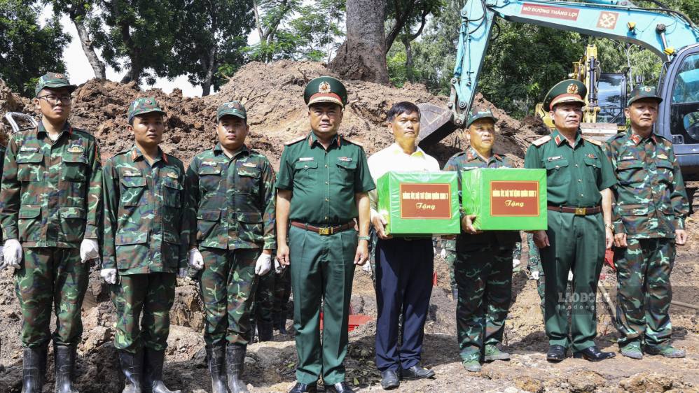Trung tướng Lê Xuân Thế, Tư lệnh Quân khu 7 (áo số 2 từ phải sang) trao quà, động viên lực lượng đang thực hiện nhiệm vụ quy tập hài cốt liệt sĩ tại Công viên Lê Thị Riêng ngày 7.8.