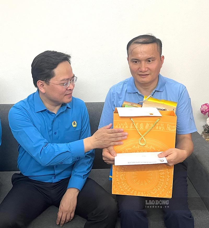 Member of the Party Central Committee, Chairman of the Vietnam General Confederation of Labour Nguyen Anh Tuan presents gifts from the program and encourages Mr. Cao Van Tuan (right). Photo: Kieu Vu