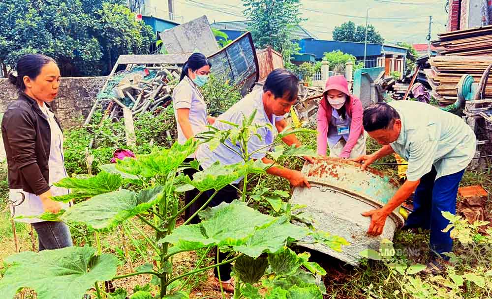 Lật úp các vật dụng chứa nước để ngăn muỗi sinh sôi, phát triển ở xã Kỳ Hoa. Ảnh: Hoàng Anh