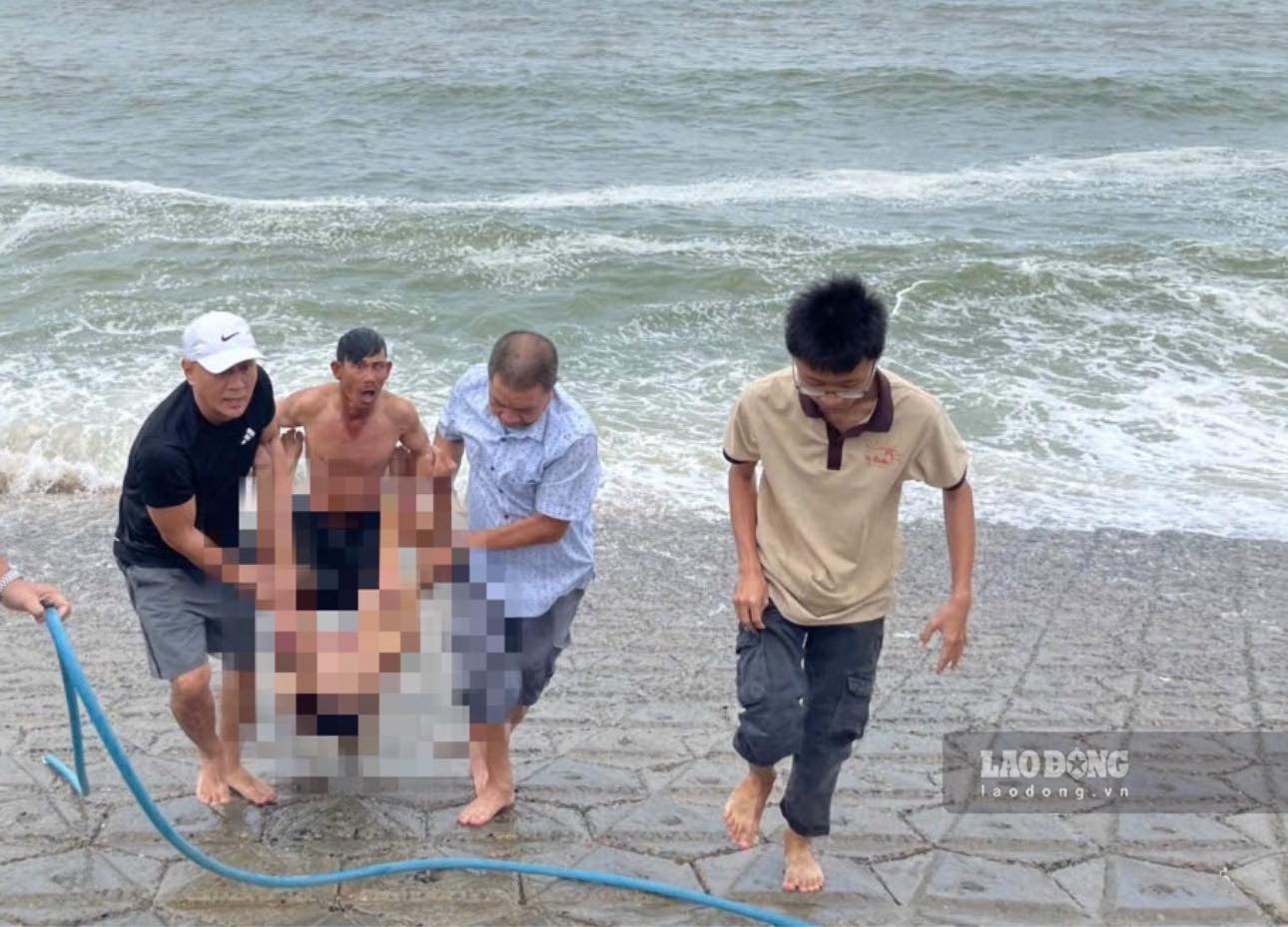 Người dân phát hiện thi thể người trôi dạt vào bờ biển và đưa lên bờ. Ảnh: Duy Tuấn 