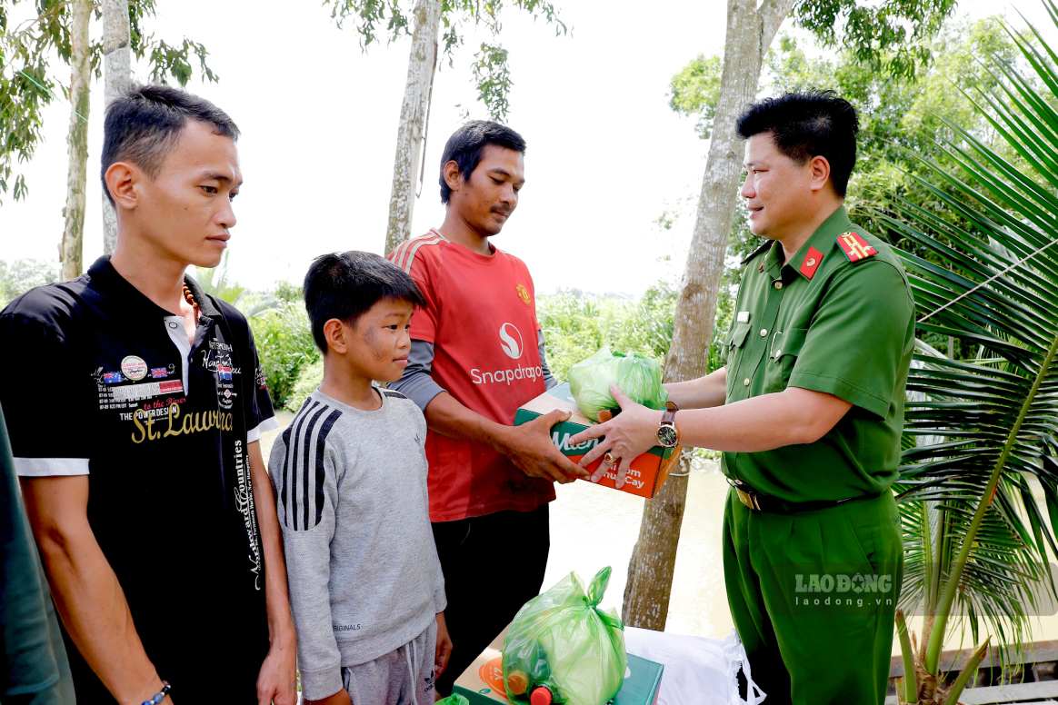Lực lượng Công an phối hợp các mạnh thường quân trao 10 phần quà cho các hộ dân có hoàn cảnh khó khăn. Ảnh: Tạ Quang
