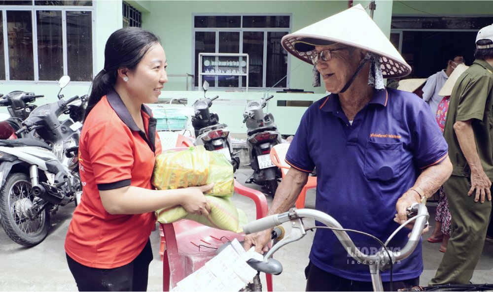 Chị Nguyễn Thúy Hằng trao quà cho những cô chú lớn tuổi làm nghề bán vé số trên địa bàn phường Rạch Giá. Ảnh: Nguyên Anh