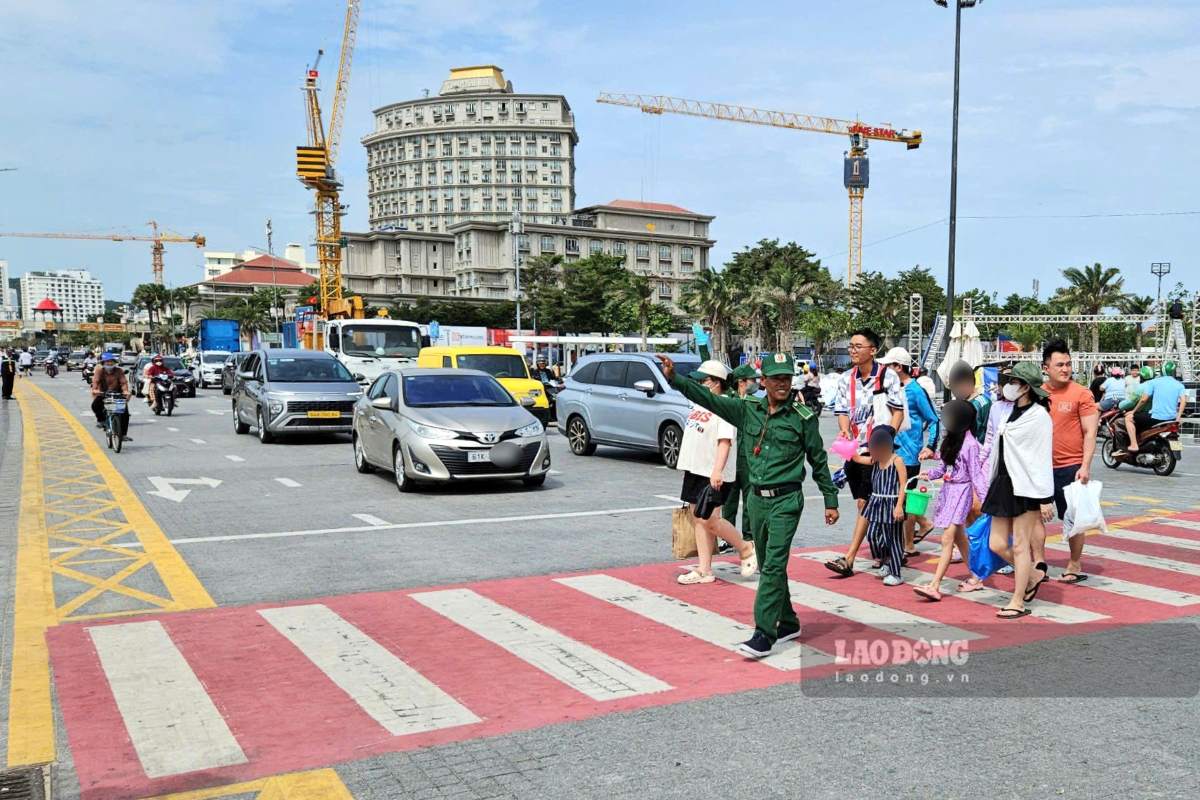 Tourist Traffic Police support and guide tourists to cross the road safely at Tam Thang Square, Vung Tau ward. Photo: Thanh An