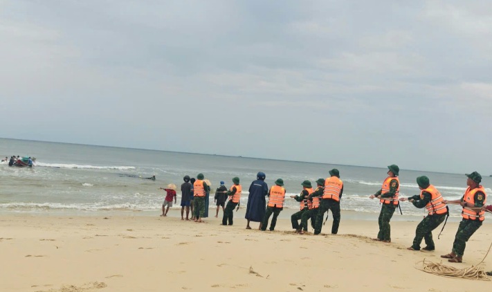 Military and civilian forces coordinate to pull a fishing boat that sank at sea. Photo: Cua Viet port border guard station