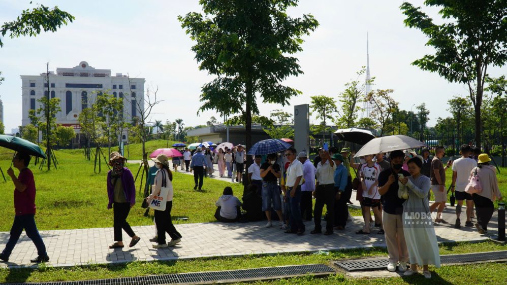 Du khách mang theo ô, mũ chống nắng để tham quan khu vực ngoài trời.