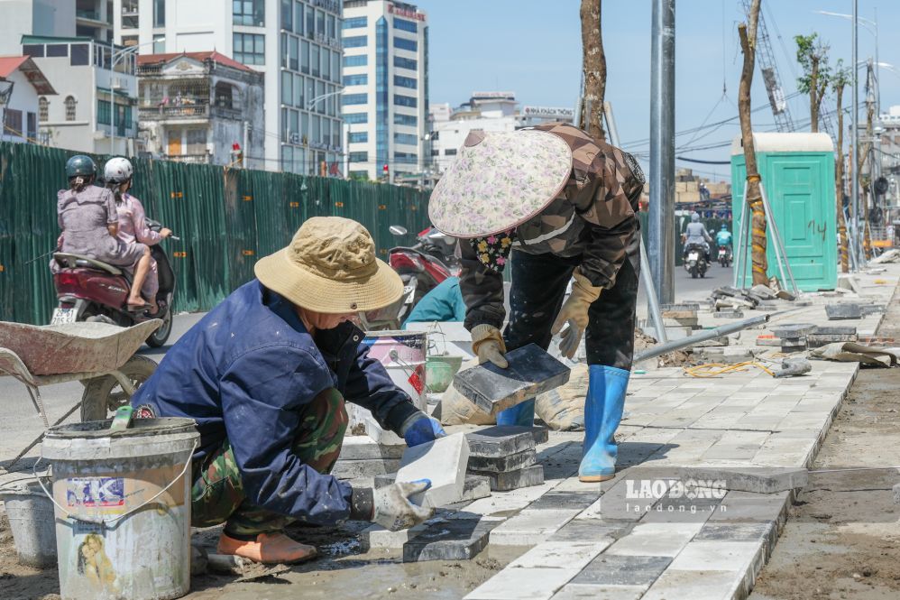 Công nhân thi công lát đá vỉa hè dự án đường Vành đai 1, sáng 1.9. Ảnh: Sóng Hữu 