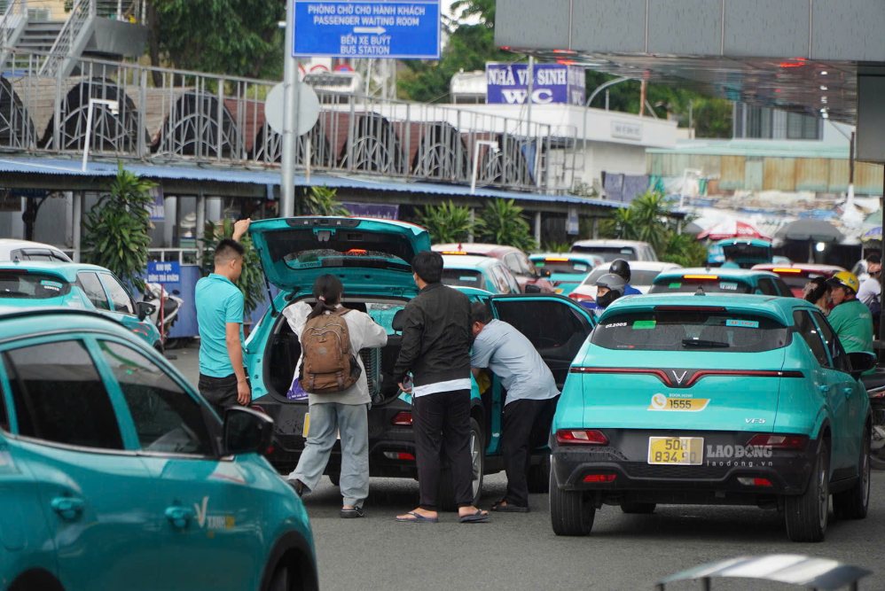 Người dân tranh thủ đặt xe công nghệ để tiếp tục hành trình về nhà sau khi xuống bến. Ảnh: Chân Phúc