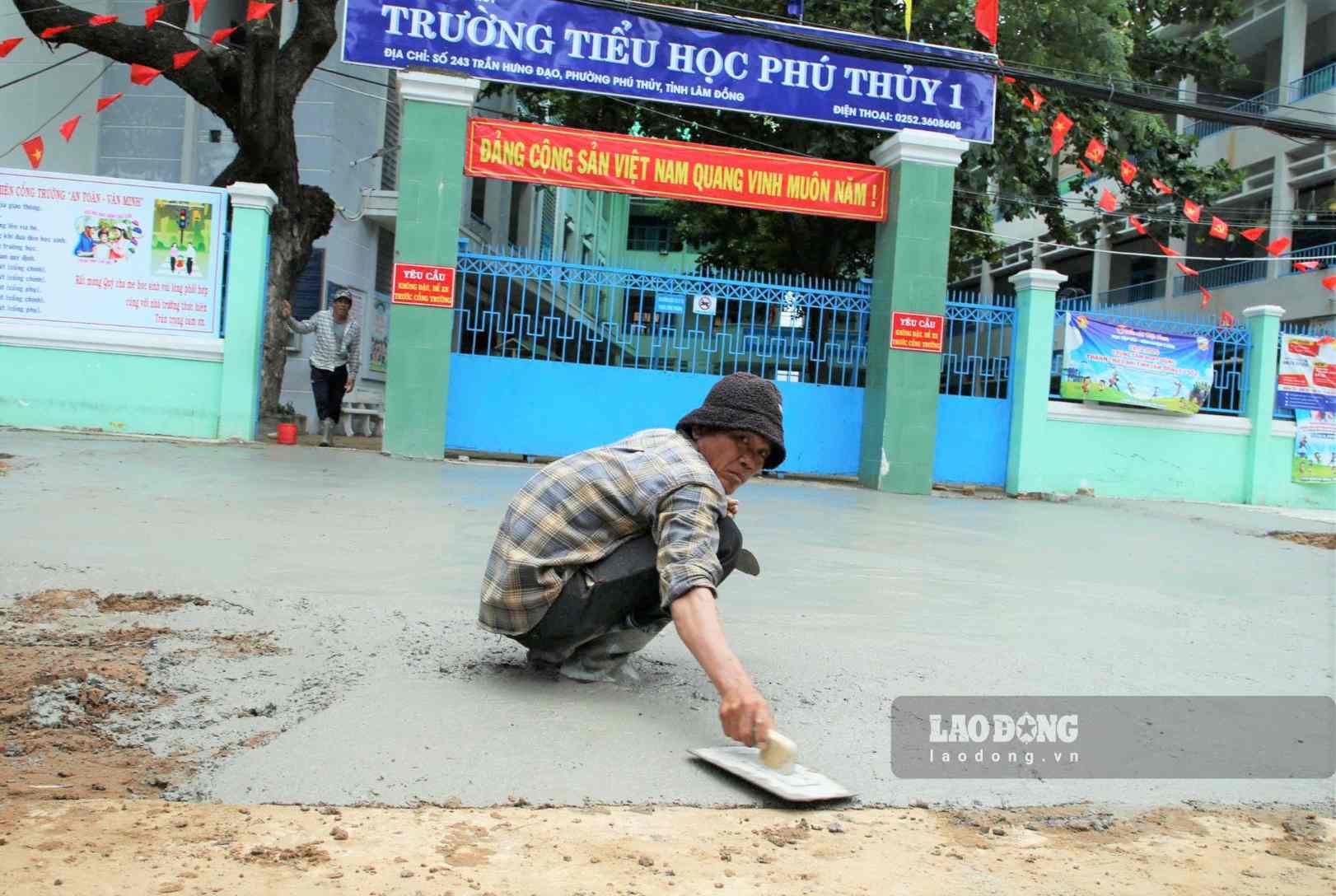 Công nhân Công ty Trường Long gấp rút hoàn thiện các hạng mục trước Trường Tiểu học Phú Thủy 1, chuẩn bị cho ngày khai giảng 5.9. Ảnh: Luân Nguyễn 