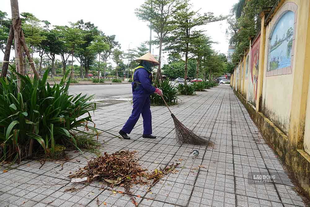Chị Hà quét rác ở đường Nguyễn Huy Oánh. Ảnh: Trần Tuấn