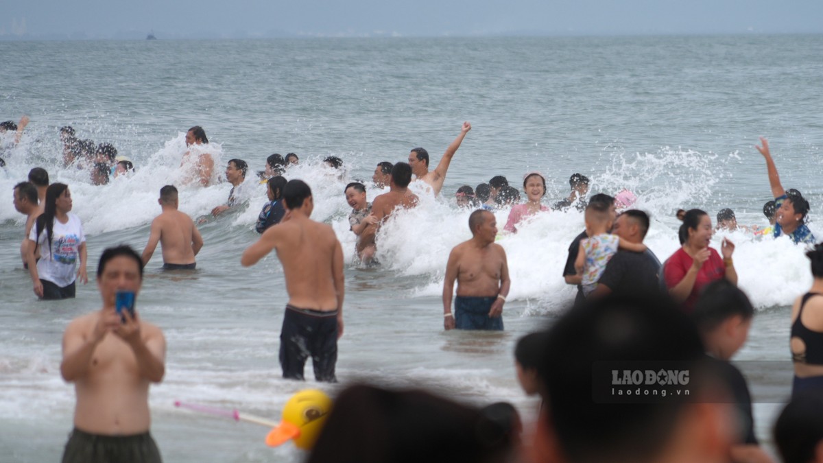 Nhiều du khách hào hứng với những cơn sóng gần bờ. Ảnh: Thành An
