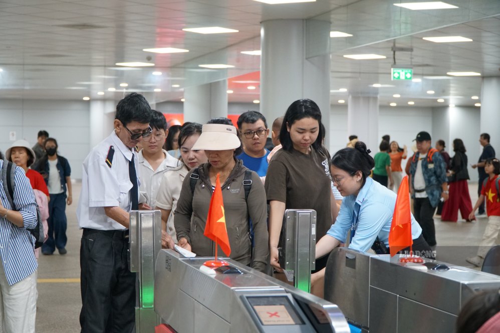 Nhân viên nhà ga hỗ trợ người dân tại khu vực soát vé. Ảnh: Ngọc Ánh