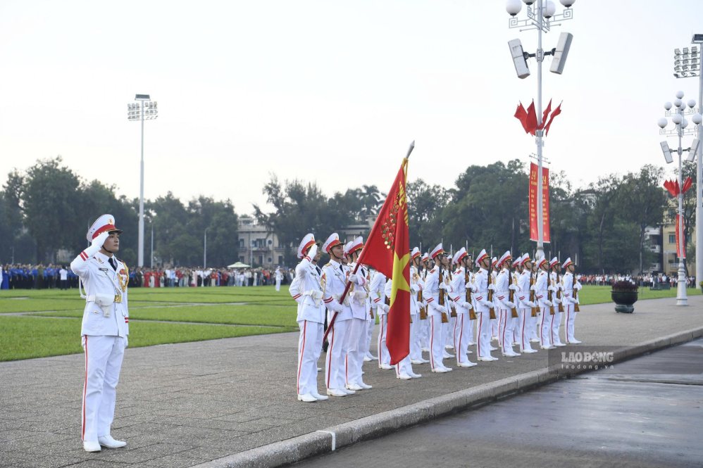 Đội tiêu binh nghiêm trang chào cờ khi Quốc kỳ được kéo lên trong nền nhạc Quốc ca.