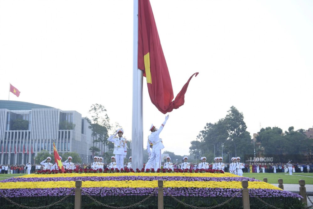 Đúng 6h, Quốc ca vang lên. Một chiến sĩ thực hiện động tác tung cờ khi Quốc kỳ dần được kéo lên đỉnh cột.