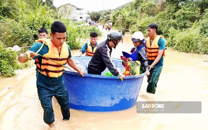 Lực lượng chức năng hỗ trợ người dân qua lại trên tuyến đường bị ngập. Ảnh chụp sáng 10.9 (Ảnh: Phúc Khánh) 