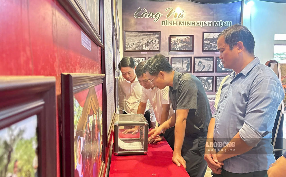 Lãnh đạo địa phương và người dân tham quan các hình ảnh của Làng Nủ sau trận lũ. 
