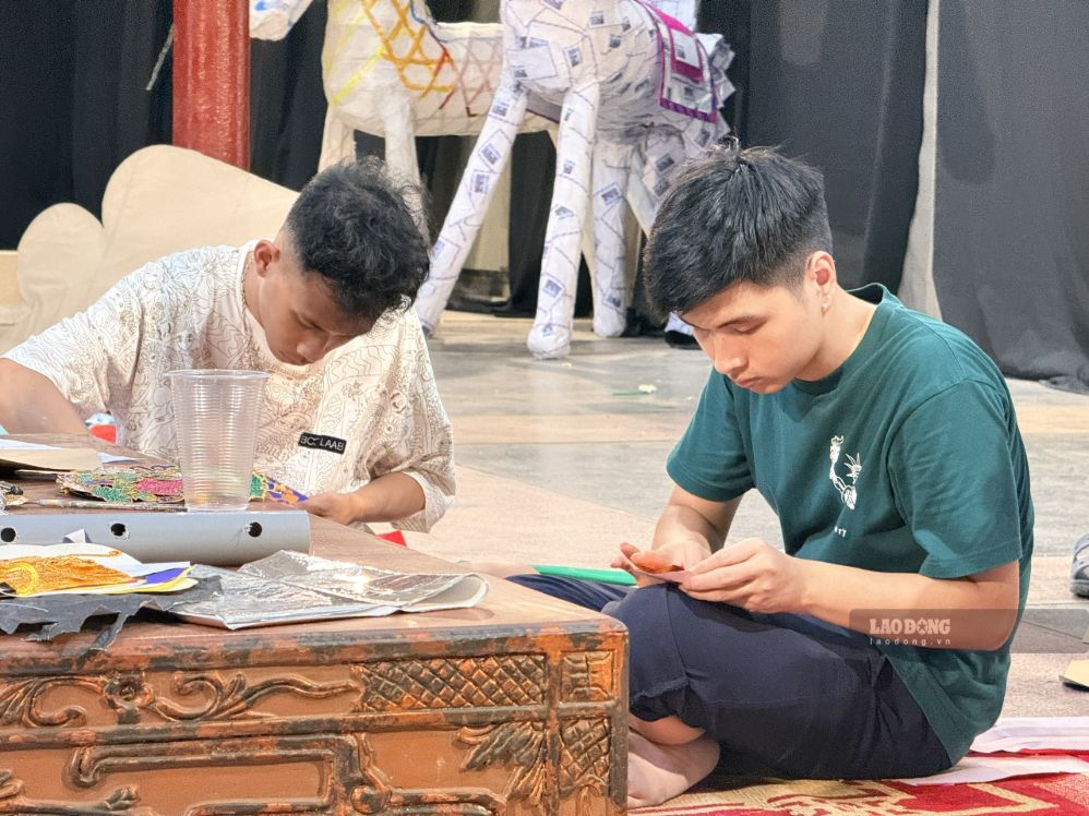Nghệ nhân Đức Anh - thành viên thương hiệu The Annam - đang chăm chút từng mảnh giấy trong quá trình phục dựng đồ chơi Trung thu. Ảnh: Thảo Anh