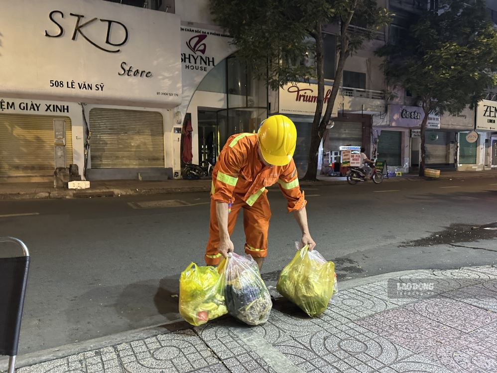 Nhân viên thu gom rác trên đường Lê Văn Sỹ ngày 7.9. Ảnh: Minh Tâm