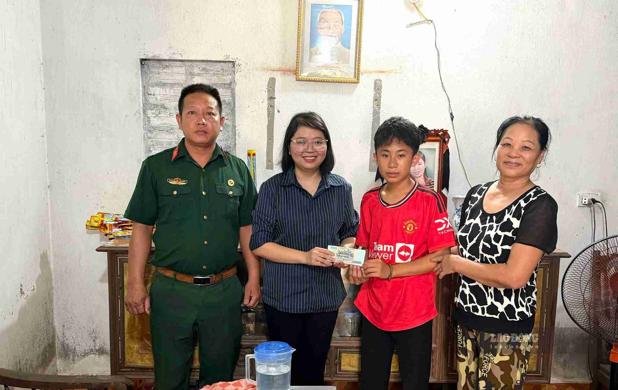 Em Bùi Thành Đạt xúc động khi đón nhận sự sẻ chia từ bạn đọc Báo Lao Động và Quỹ Thiện Tâm. Ảnh: Hải Minh