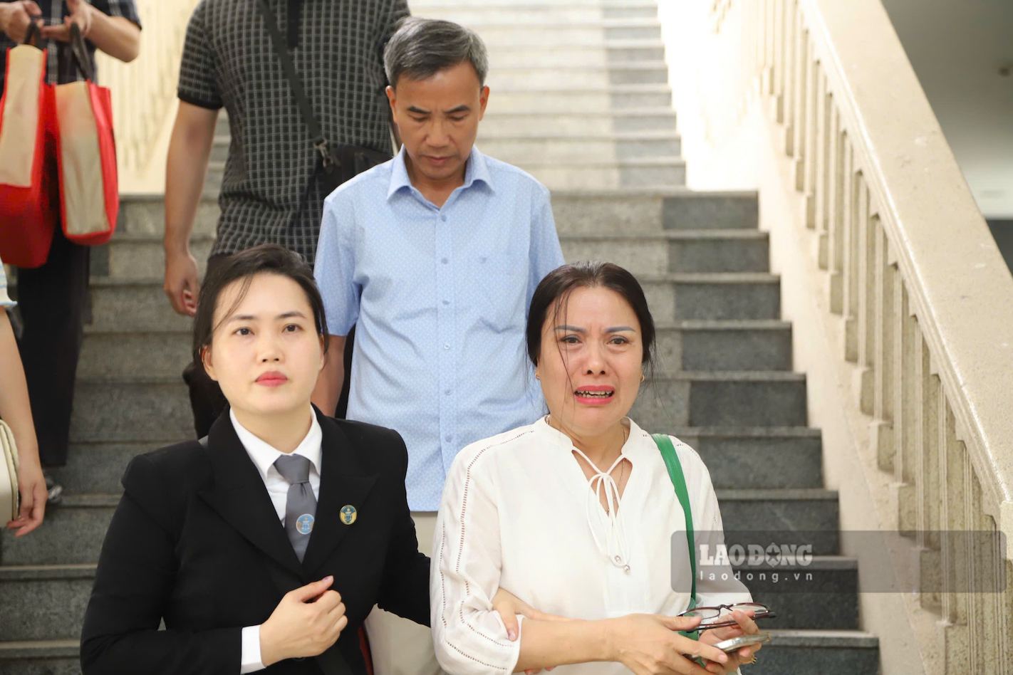 元校長のグエン・ティ・ビン氏と弁護士が昼の法廷を後にする。9. 写真:トゥオン・ヴァン