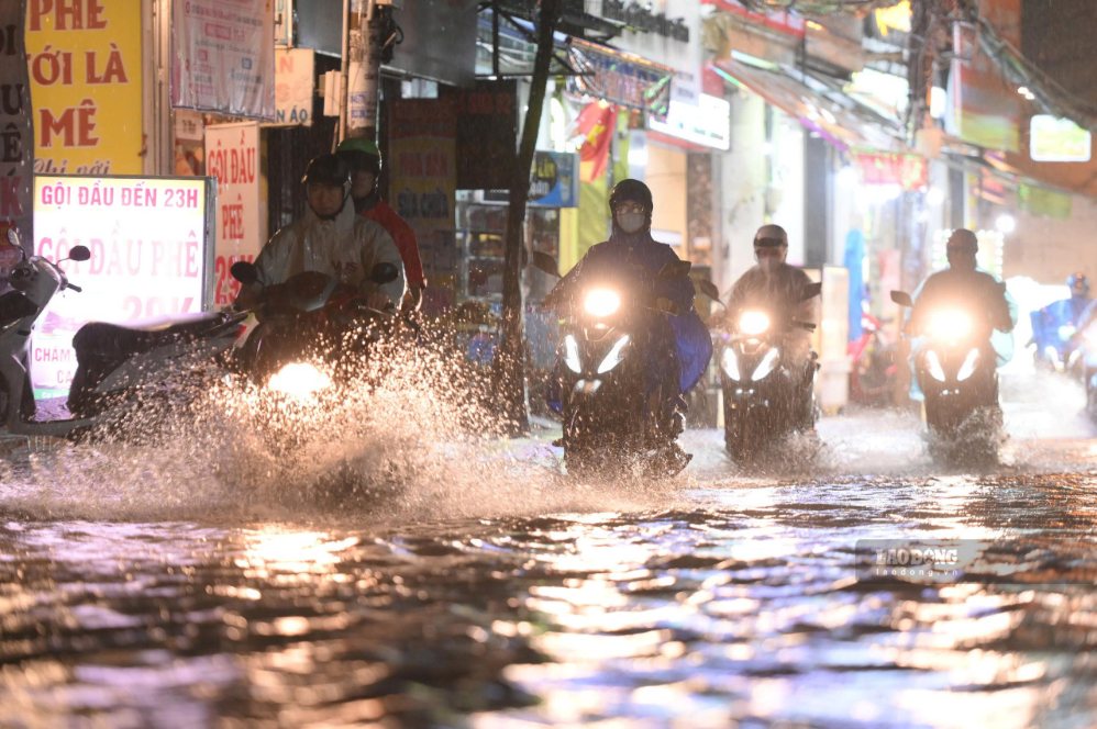 Nước mưa phủ mặt đường Nguyễn Văn Khối, nhiều xe máy phải giảm tốc độ để tránh chết máy. Ảnh: Thái Bảo