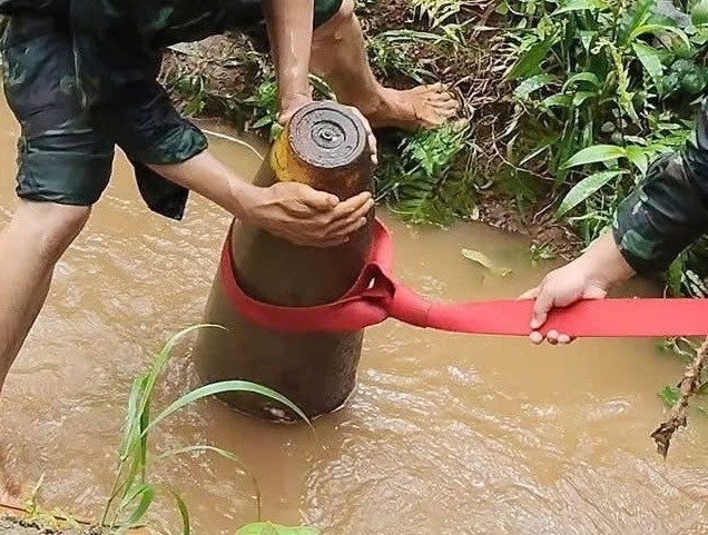 À travers une bombe découverte dans un ruisseau du village 2, commune de Bom Bo. Photo: Commandement militaire de la commune de Bom Bo