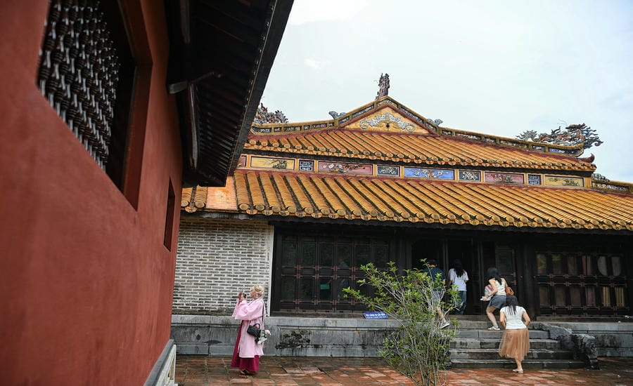 Một góc khu tẩm điện Lăng Tự Đức với những mái ngói hoàng lưu ly, các mảng trang trí rồng, mây và hoa văn khảm sành sứ nhiều màu. Giữa không gian kiến trúc cổ, du khách hôm nay tạo nên những chuyển động mới cho di sản.