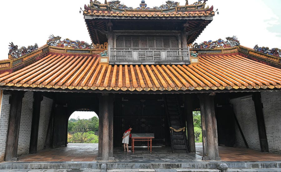 Mặt sau Khiêm Cung Môn nổi bật với mái ngói hoàng lưu ly và những mảng trang trí rồng, mây được đắp nổi, khảm sành sứ tinh xảo. Sắc vàng, cam và xanh trên mái tương phản với hệ khung gỗ sẫm màu bên dưới, tạo nên vẻ cầu kỳ đặc trưng của kiến trúc cung đình Nguyễn