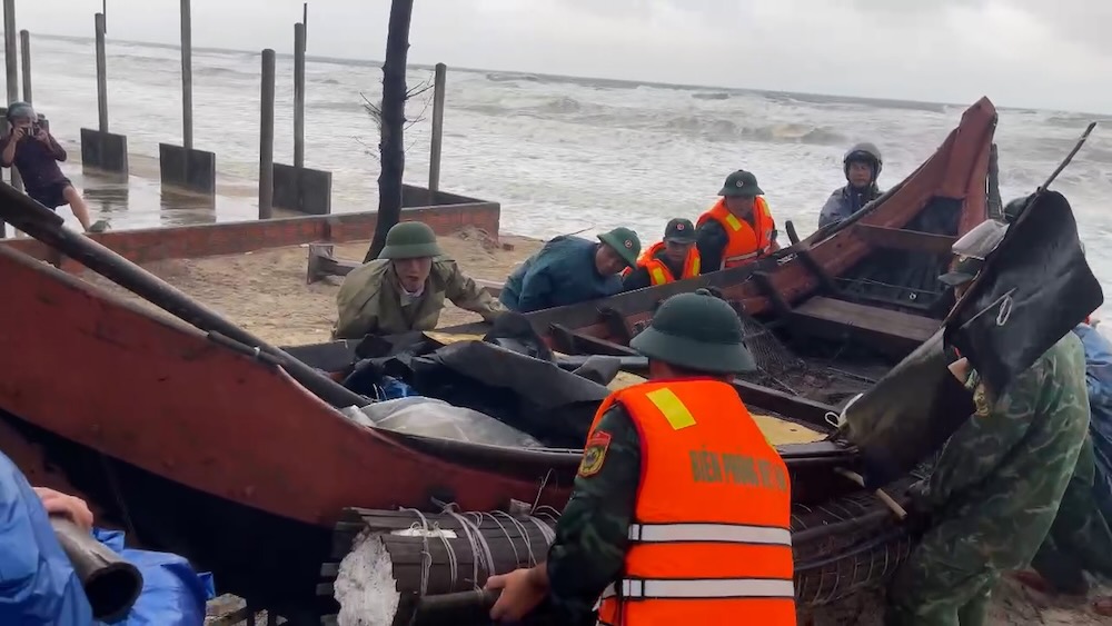 Các lực lượng khẩn trương kéo ghe, thuyền lên khu vực an toàn trong điều kiện mưa lớn chiều 12.9. Ảnh: UBND xã Mỹ Thủy cung cấp