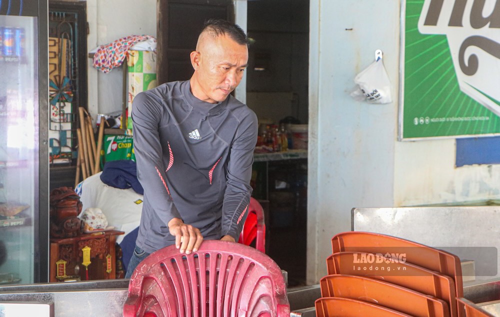 Anh Trần Đại Chiến chuẩn bị thu dọn bàn ghế, tài sản trong chiều 12.9 trước diễn biến bất lợi của thời tiết. Ảnh: Phúc Đạt