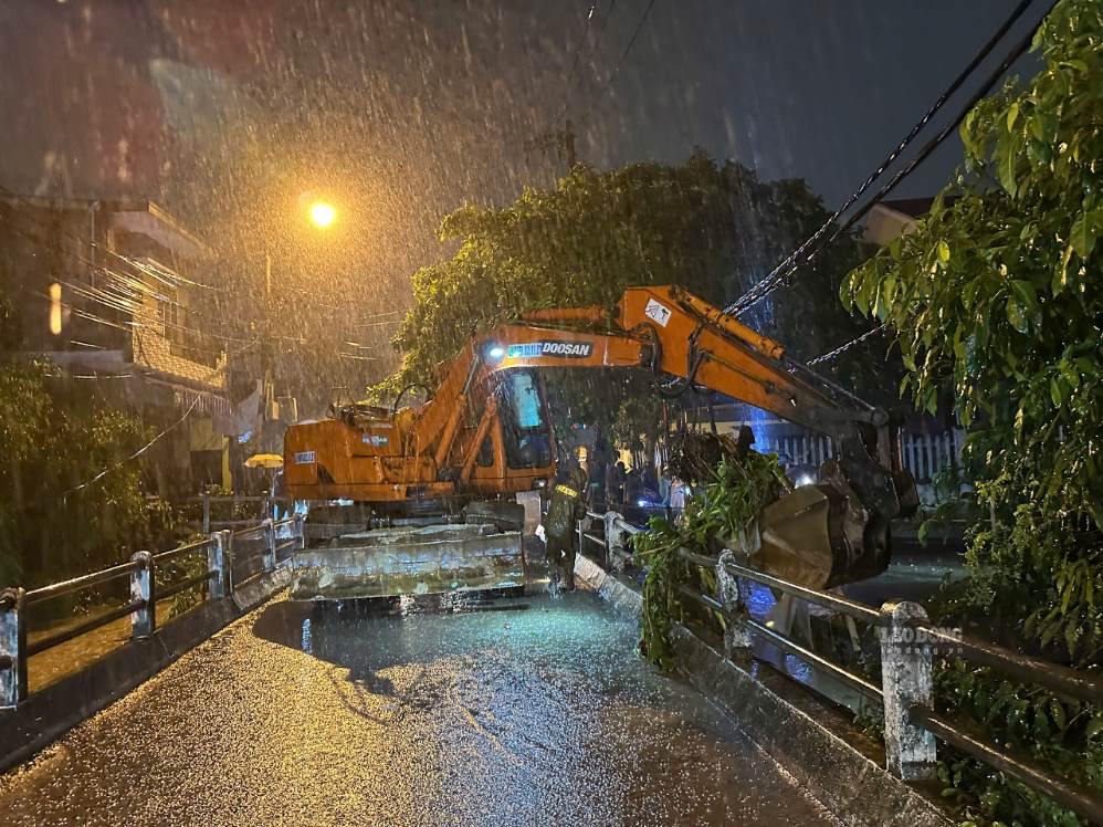Lực lượng chức năng các phường túc trực tại các điểm ngập trũng để hỗ trợ người dân và đảm bảo an toàn giao thông. Ảnh: Nguyễn Linh