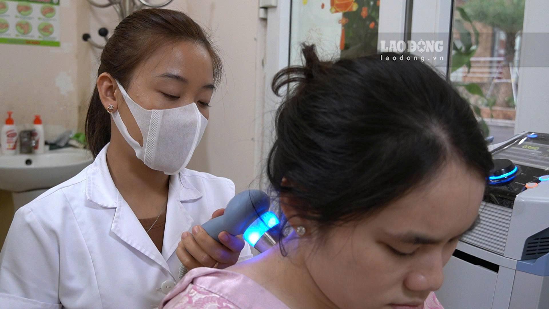 Chị Nguyễn Thanh Tú đang điều trị đau cổ vai gáy bằng phương pháp siêu âm trị liệu. Ảnh: Hạnh Thơm 