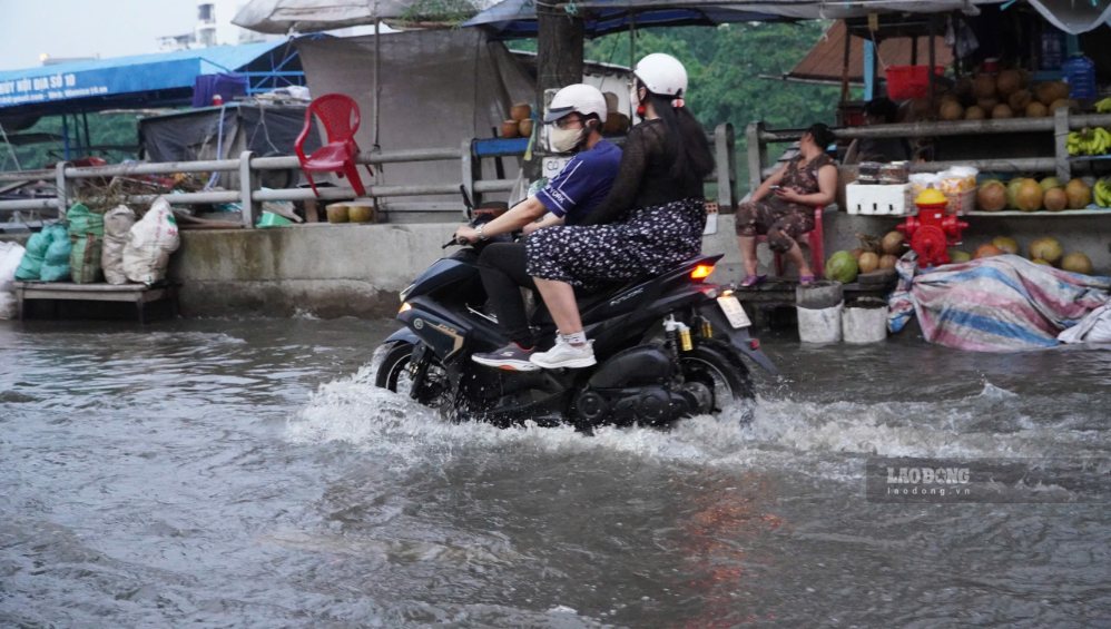 Mưa lớn kết hợp triều cường khiến đường Trần Xuân Soạn ngập nước, người dân chật vật di chuyển. Ảnh: Thái Bảo