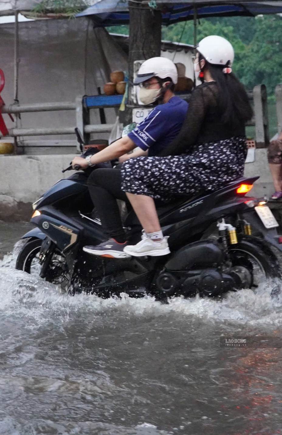 TPHCM mưa lớn gặp triều cường, người dân chật vật vượt đường ngập.
