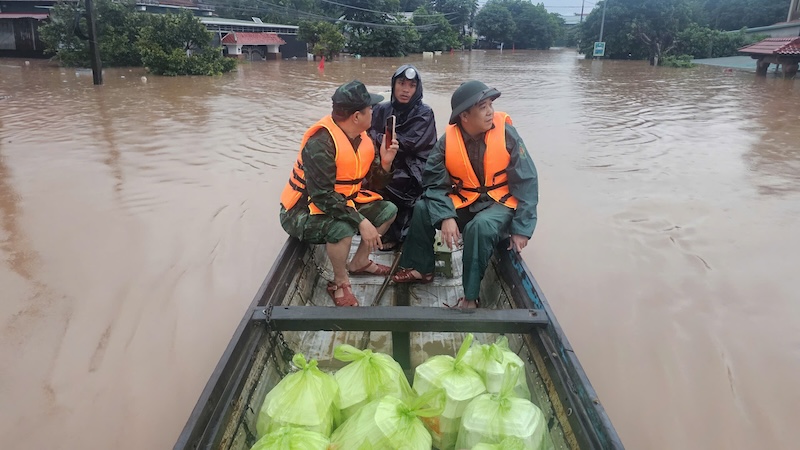 Thuyền vượt dòng nước lũ đưa cơm vào cho người dân. Ảnh: UBND xã Lao Bảo
