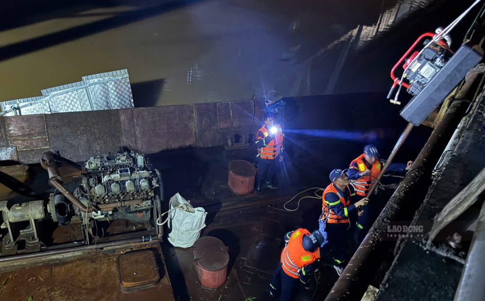 Tối 13.9, lực lượng cứu hộ triển khai các biện pháp bảo đảm an toàn cho cầu đường sắt khi sà lan mắc kẹt bên dưới. Ảnh: Hàn Nguyên
