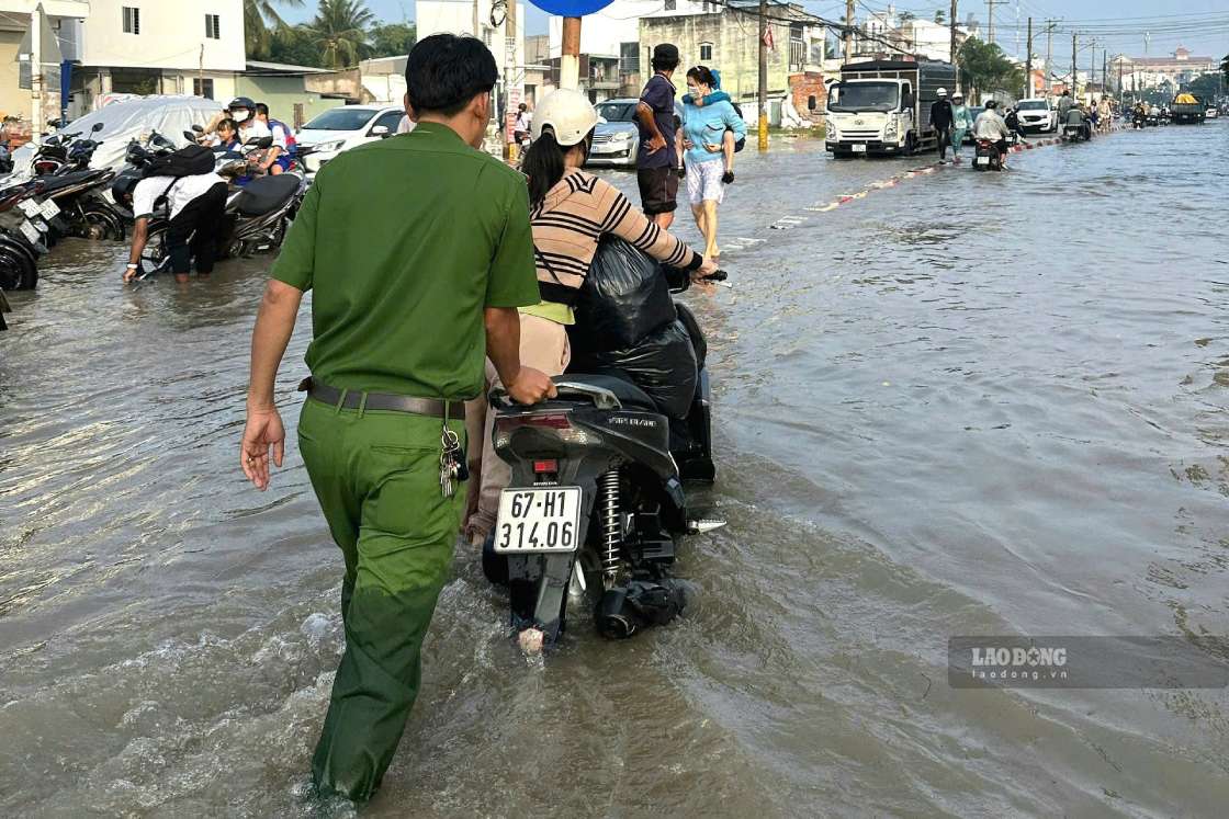 Lực lượng chức năng điều tiết giao thông và hỗ trợ người dân qua vị trí sâu. Ảnh: Tạ Quang (ảnh chụp ngày 14.9)