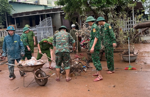 Hỗ trợ người dân dọn bùn ở xã Lao Bảo trong sáng 14.9. Ảnh: Biên phòng Quảng Trị