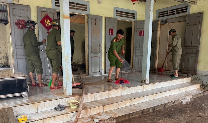Quét bùn khỏi các ngôi nhà ngập nước lũ ở xã Lao Bảo trong sáng 14.9. Ảnh: Biên phòng Quảng Trị