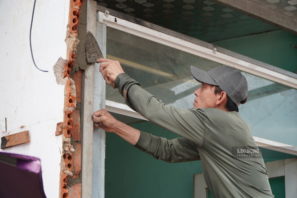 Người dân sửa chữa, gia cố lại nhà sau khi tháo dỡ một phần công trình để phục vụ dự án mở rộng Quốc lộ 24B. Ảnh: Viên Nguyễn chụp ngày 13.9