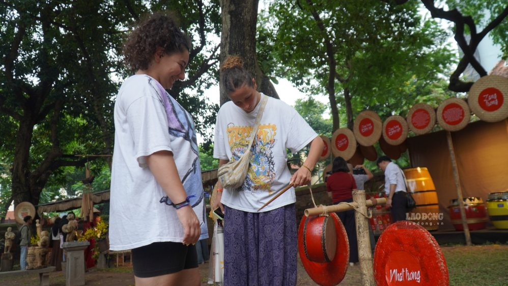 Du khách nước ngoài trực tiếp cầm dùi, trải nghiệm tiếng trống truyền thống Việt Nam. Ảnh: Minh Vũ