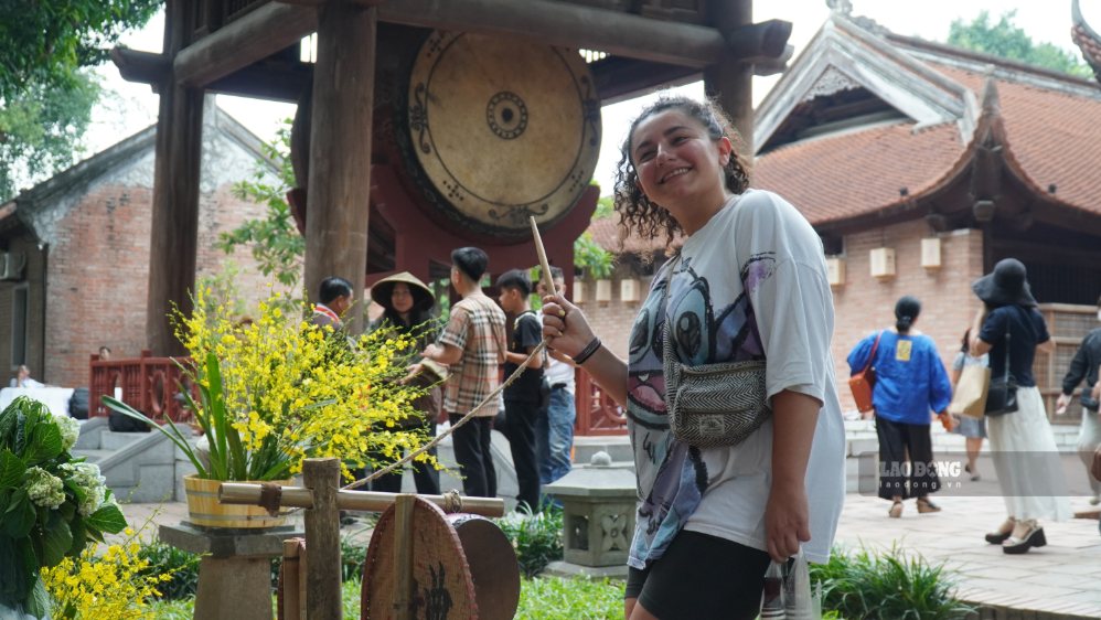 Chị Wilding trải nghiệm những chiếc trống với kiểu dáng, kích thước khác nhau được giới thiệu tại chương trình. Ảnh: Minh Vũ