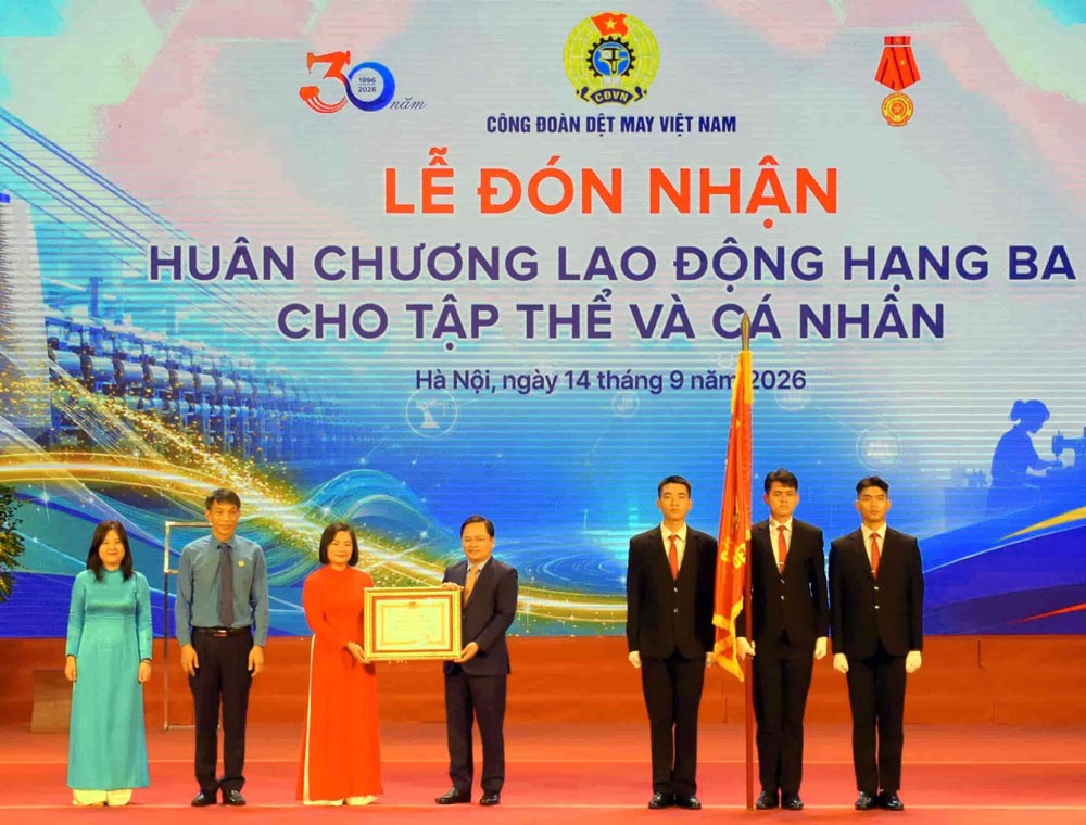 M. Nguyễn Anh Tuấn - membre du Comité central du Parti, président de la Confédération générale du travail du Vietnam - remet l'Ordre du travail de troisième classe au Syndicat vietnamien du textile et de l'habillement. Photo: Thu Mai/Syndicat vietnamien du textile et de l'habillement