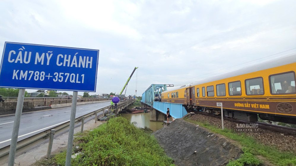 Đoàn tàu di chuyển bình thường qua cầu đường sắt Mỹ Chánh sau sự cố các sà lan bị cuốn trôi rồi mắc kẹt dưới gầm cầu. Ảnh: Hưng Thơ