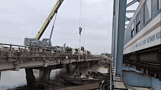 Using a 55-ton crane to pull the largest barge stuck at My Chanh bridge. Photo: Hung Tho